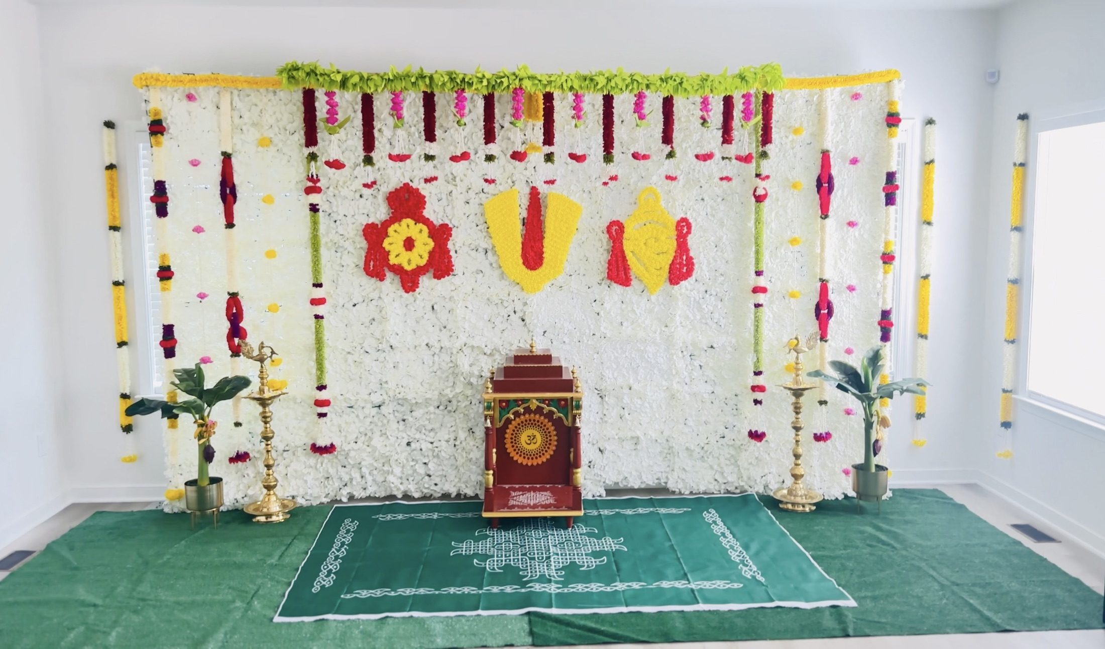 White floral traditional ceremony backdrop with red and yellow floral symbols