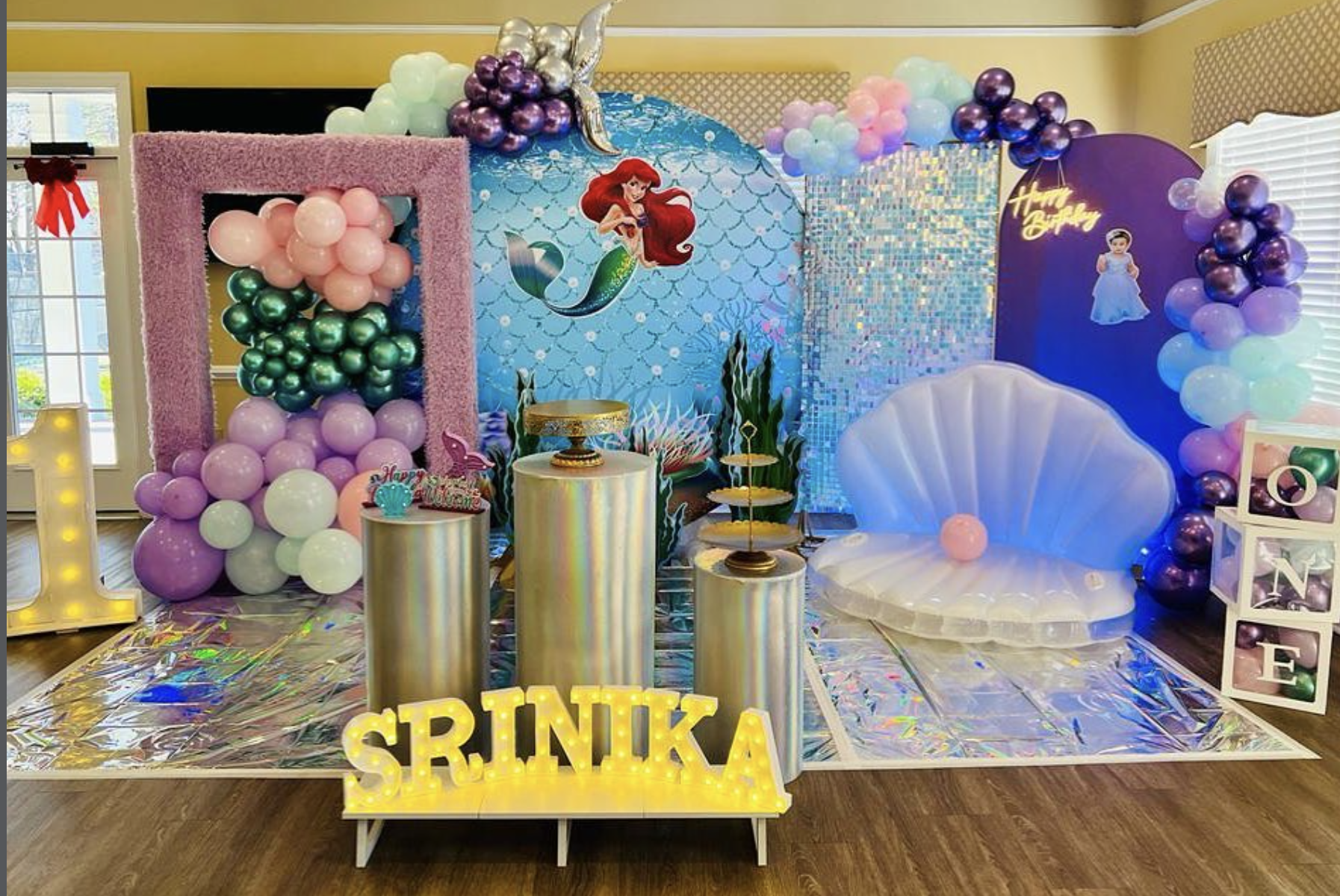 Pastel mermaid birthday celebration with balloons, panels, and illuminated name letters