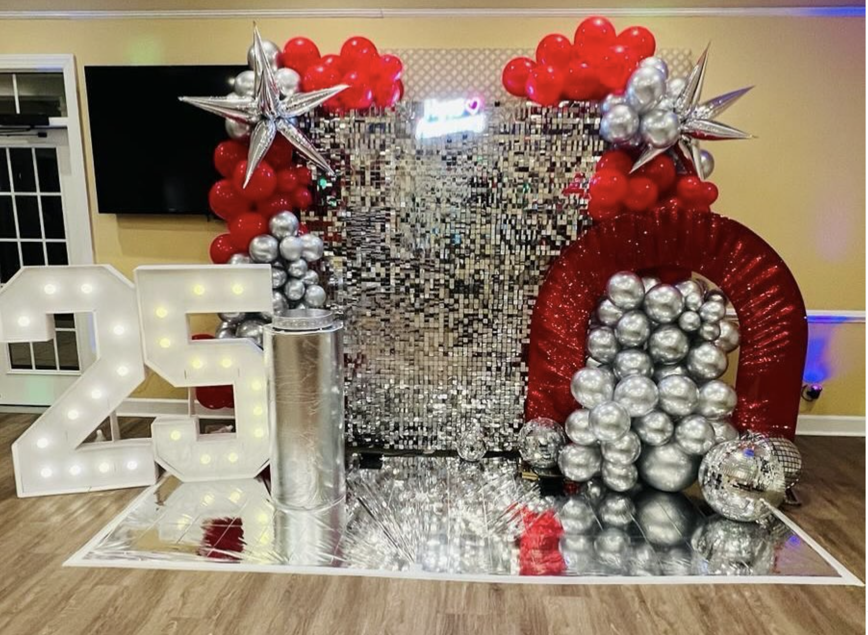 Silver and red milestone birthday display with balloons and marquee numbers